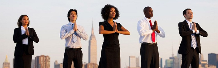 Cinq personnes en tenu professionnel pratiquant la méditation